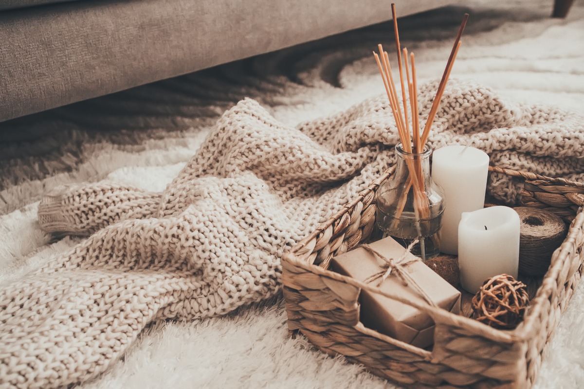 NEUTRAL/NATURAL color psychology: Candle and knitting clothes in wicker basket